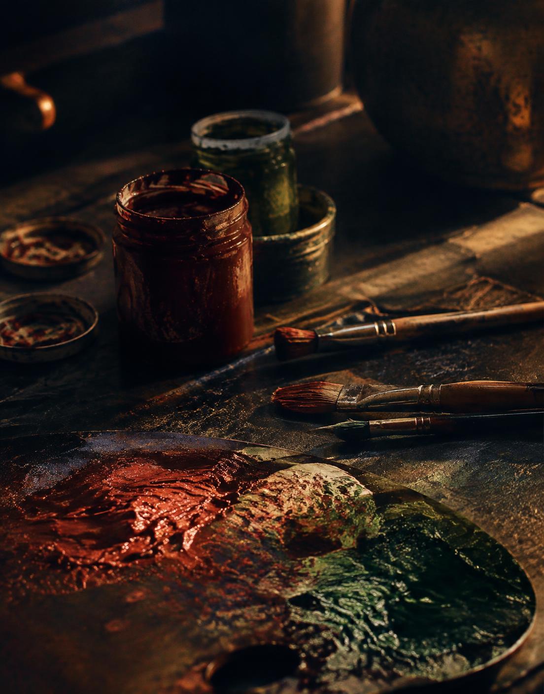 Paint jars, brushes and a palette of red and green pigment